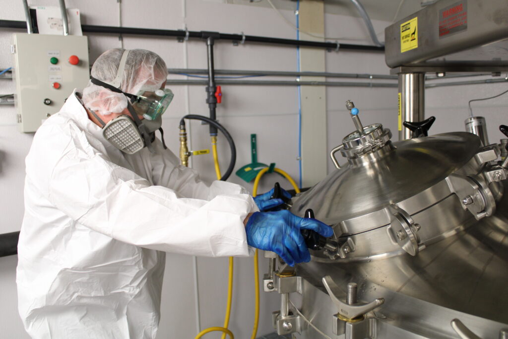 worker in suit working on kettle on manufacturing floor
